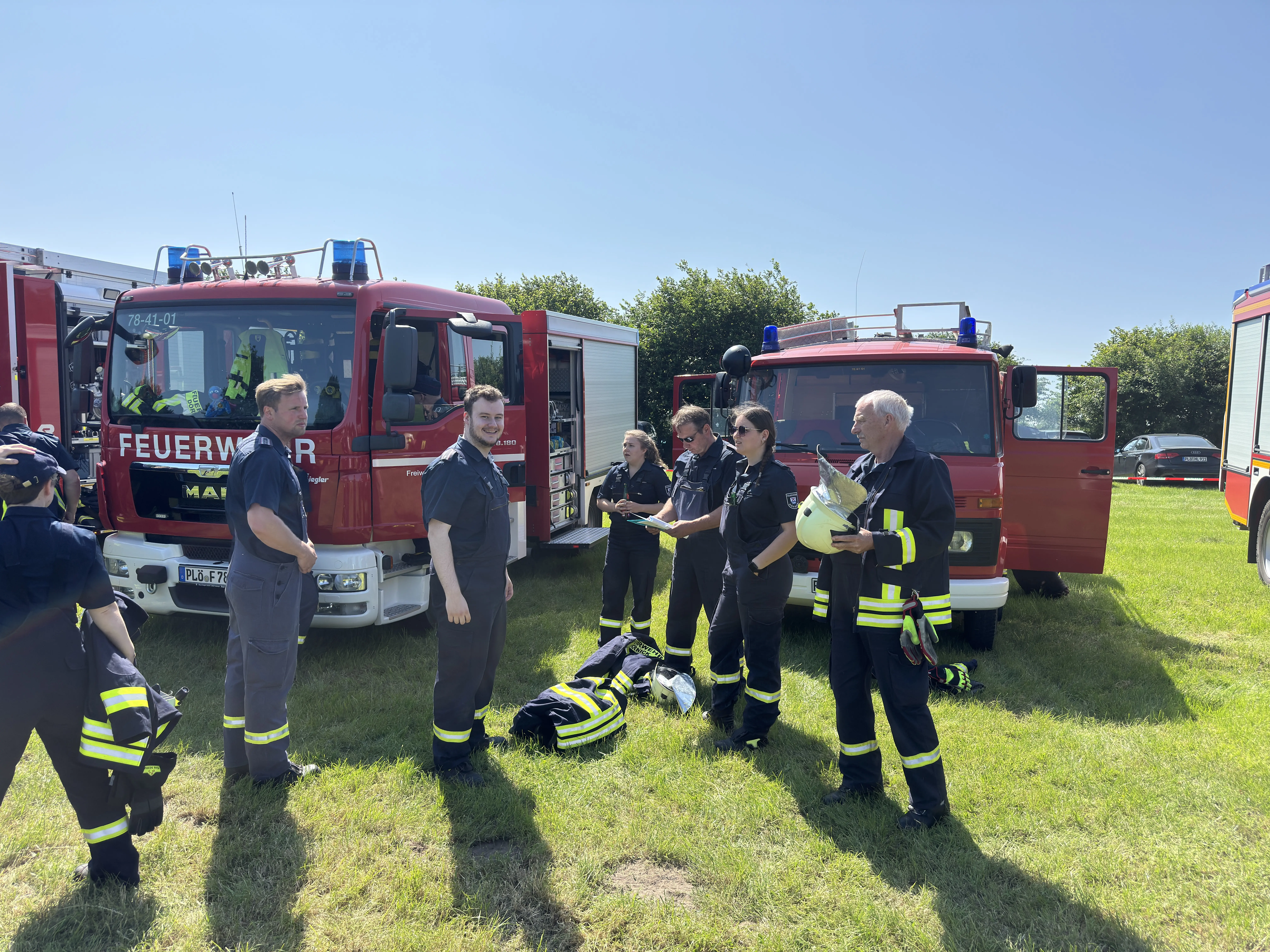 8 Feuerwehrmänner/Frauen sitzen gemeinsam am Tisch